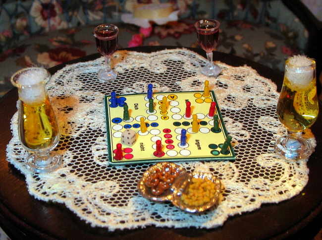 На столе мирно соседствуют бокалы и рюмки с вином и пивом и детская игра